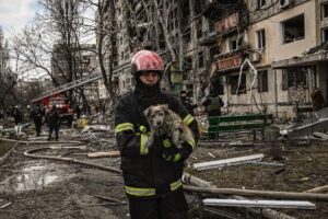 Ukraiński strażak niesie na rękach psa